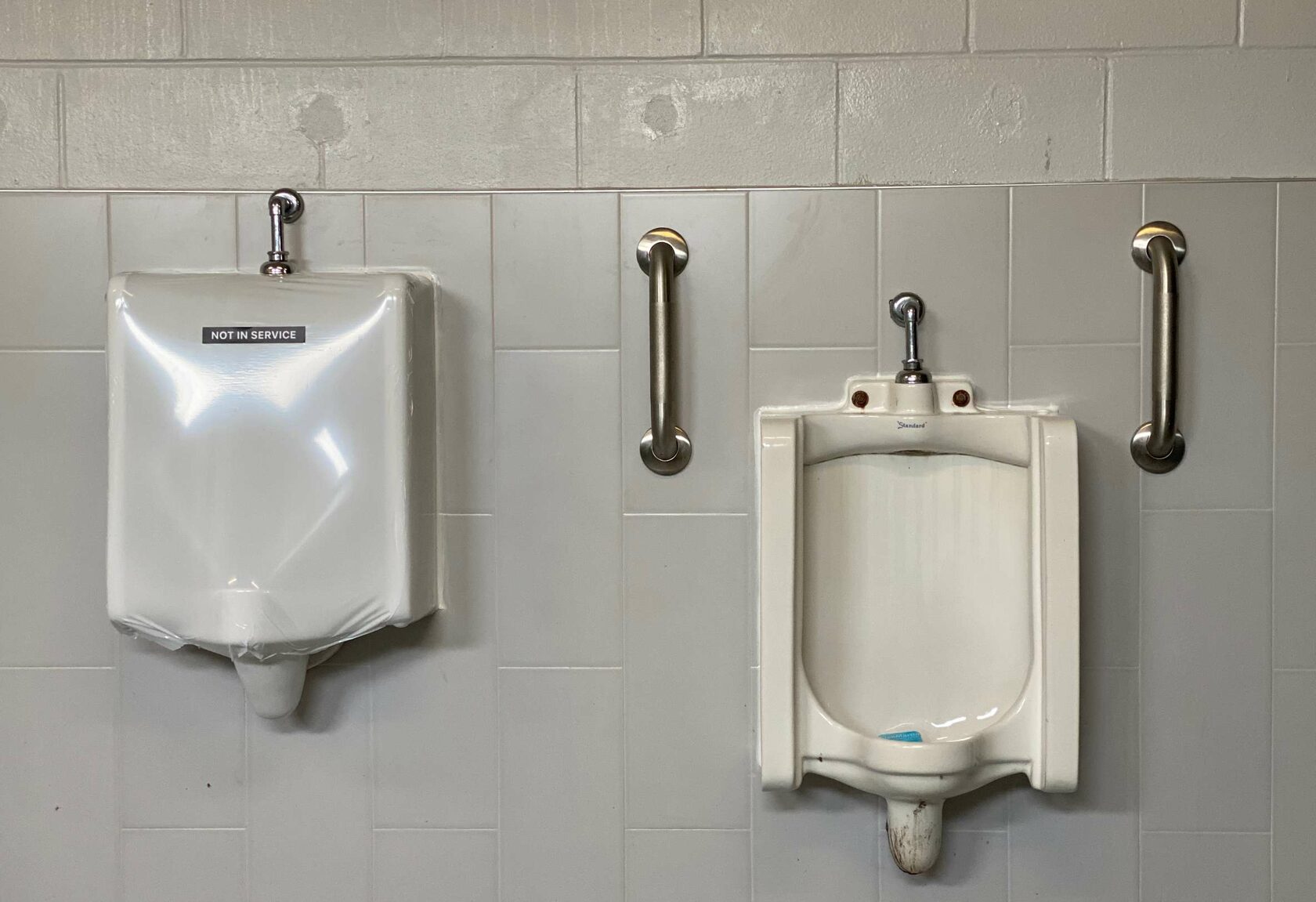 SaniCover urinal cover in a commercial restroom